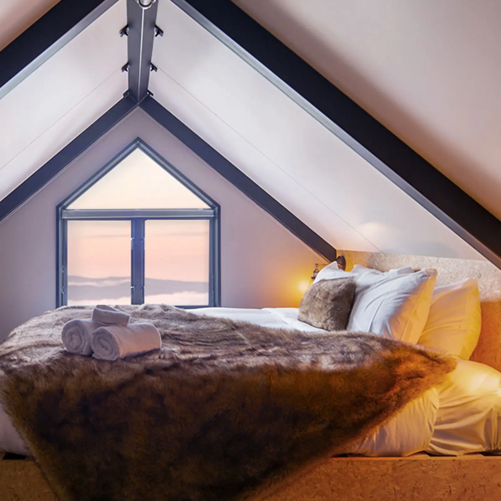 A modern studio apartment with a queen bed and stunning alpine views out the bedroom window.