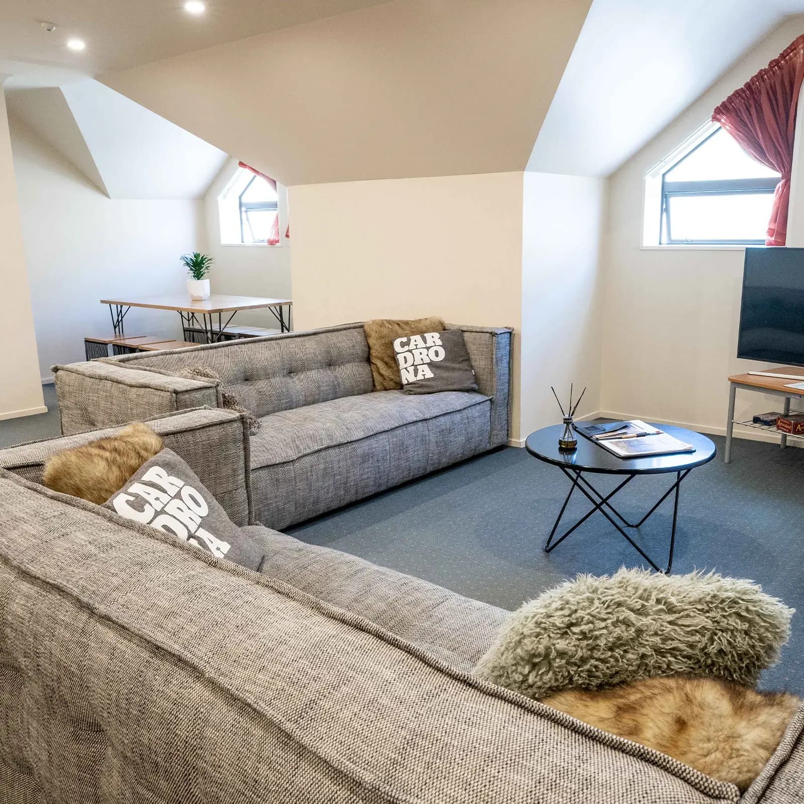 A spacious three bedroom apartment with comfy looking couches a coffee table and tv.